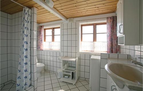 NeksøにあるNice Home In Nex With House Sea Viewのバスルーム(洗面台、トイレ、窓付)