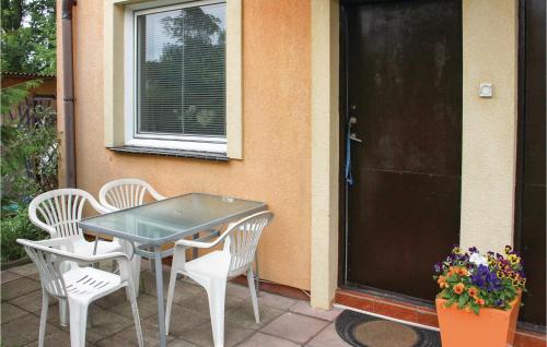 a table and chairs on a patio next to a door at Nice Home In Rewal With 1 Bedrooms in Rewal
