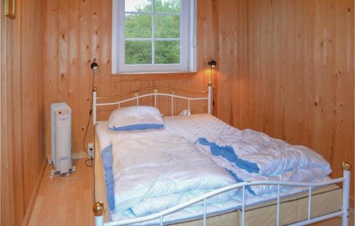 uma cama num quarto de madeira com uma janela em Beautiful Home In Ansager With 3 Bedrooms And Wifi em Ansager