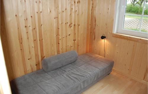 a bed in a room with a wooden wall at Holiday Home Egelunden Ansager I in Ansager
