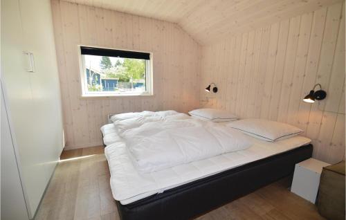 a large white bed in a room with a window at Nice Home In Rdby With Wifi in Kramnitse
