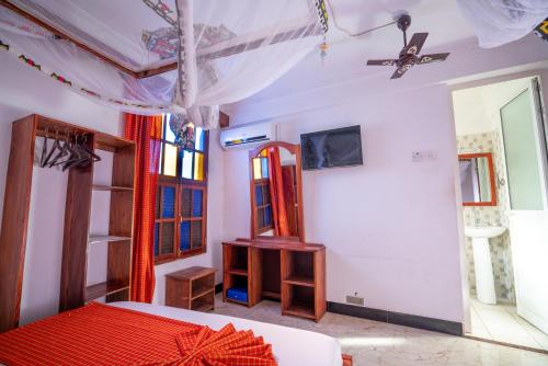 1 dormitorio con cama y techo en Stonetown View Inn, en Zanzíbar