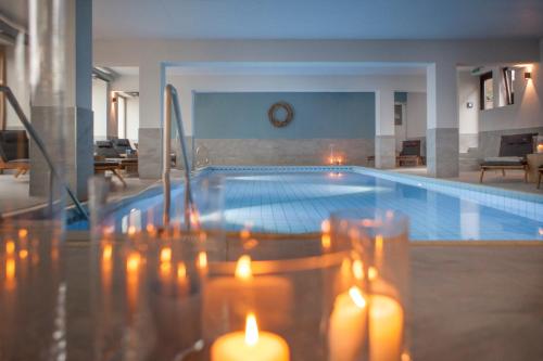 a swimming pool with lit candles in a room at Buchnas Landhotel Saarschleife in Mettlach