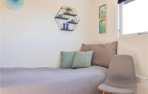 a bedroom with a bed and a chair and a window at Two-Bedroom Holiday Home In Kirke Hyllinge in Kirke-Hyllinge