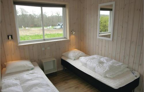 HouにあるBeautiful Home In Tranekr With Sauna, Wifi And Outdoor Swimming Poolのベッドルーム1室(ベッド2台、窓2つ付)