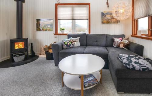a living room with a couch and a table and a stove at Three-Bedroom Holiday Home In Sydals in Skovbyballe