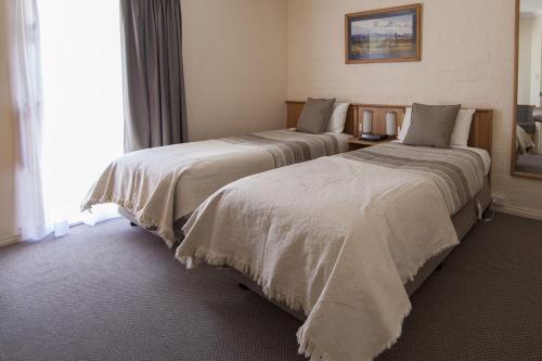two beds sitting next to each other in a room at Redhill Cooma Motor Inn in Cooma