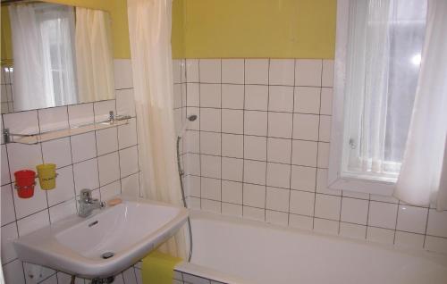 ein weißes Badezimmer mit einem Waschbecken und einer Badewanne in der Unterkunft Kanalhytten in Rømø Kirkeby