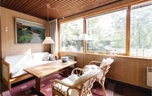 uma sala de estar com uma mesa e cadeiras e um sofá em 2 Bedroom Pet Friendly Home In Nex em Bedegård