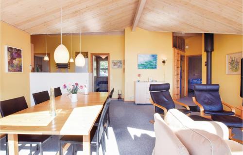 a dining room with a wooden table and chairs at Three-Bedroom Holiday Home In Humble in Humble