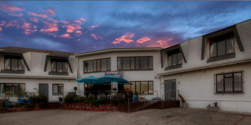 a building with an umbrella in front of it at Mermaid Guest House in Struisbaai
