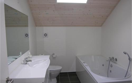 a bathroom with a tub and a toilet and a sink at Amazing Home In Stubbekbing With 3 Bedrooms in Stubbekøbing