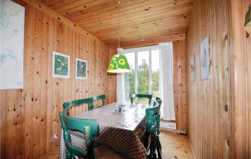 a dining room with a table and green chairs at Mugge in Ebeltoft