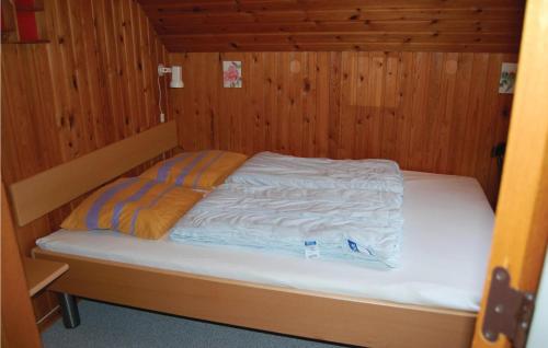 a bed in a wooden room with two pillows on it at Awesome Home In Rm With Kitchen in Bolilmark