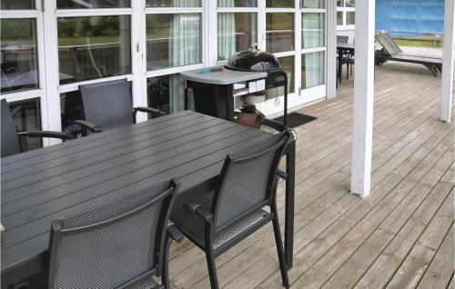 a wooden table and chairs sitting on a deck at Holiday Home Strandparken Dnmk Ii in Otterup