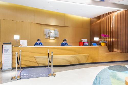 two women sitting at a counter in a hotel lobby at Holiday Inn Express Hangzhou East Station by IHG in Hangzhou