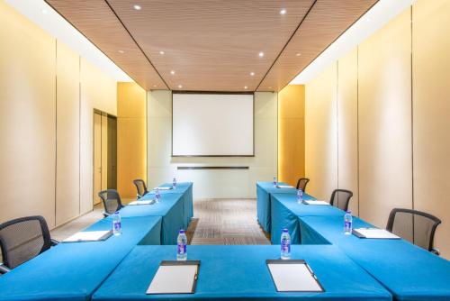 a conference room with blue tables and chairs and a projection screen at Holiday Inn Express Hangzhou East Station by IHG in Hangzhou