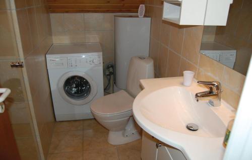 a bathroom with a toilet and a washing machine at Awesome Home In Rm With Kitchen in Bolilmark
