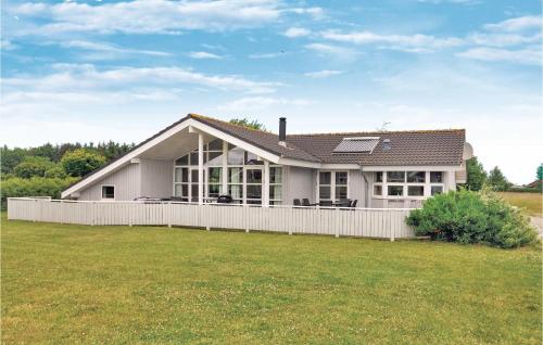 a white house with a fence in front of a yard at Holiday Home Strandparken Dnmk Ii in Otterup