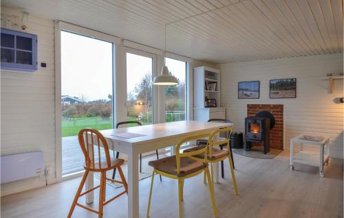 a dining room with a table and chairs and a fireplace at Two-Bedroom Holiday Home In Knebel in Knebel