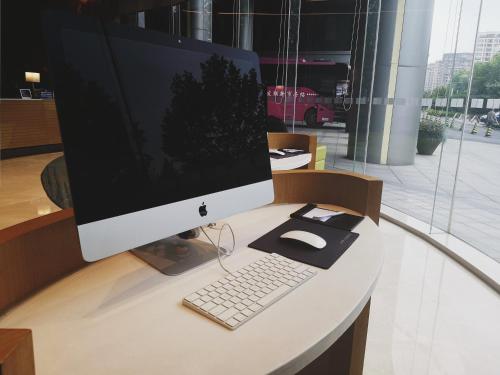 a computer monitor and a keyboard and mouse on a desk at Holiday Inn Express Hangzhou East Station by IHG in Hangzhou
