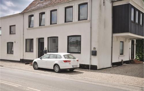 a white car parked in front of a white house at One-Bedroom Apartment In Sydals in Tandslet