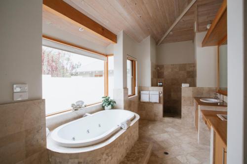 a large bathroom with a tub and a large window at Yallingup Villas in Yallingup