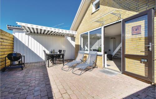 a patio with chairs and a table on a brick patio at One-Bedroom Holiday Home In Otterup in Otterup
