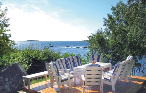 SaltärnaにあるHoliday Home Ronneby Lxxxvのテーブルと椅子が備わるデッキから水辺の景色を望めます。
