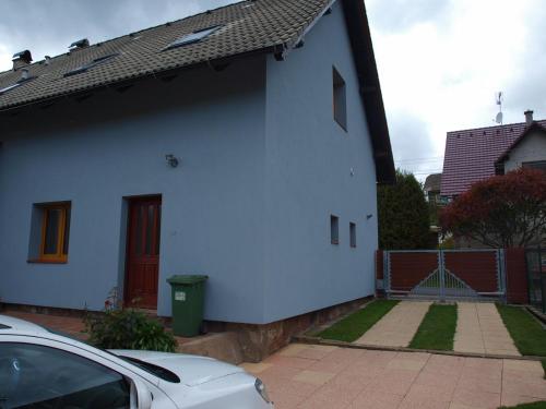 uma casa branca com um carro estacionado em frente dela em apartman17 em Syřenov