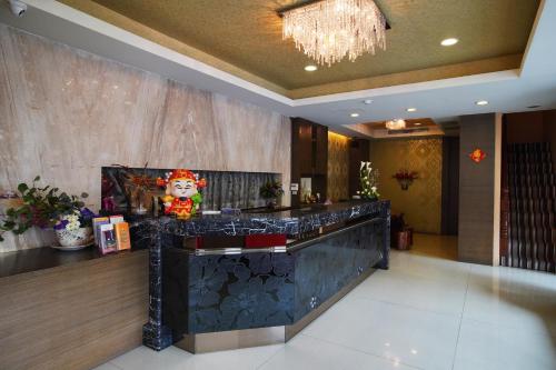 a lobby with a bar with a chandelier at Happy Hotel in Kaohsiung