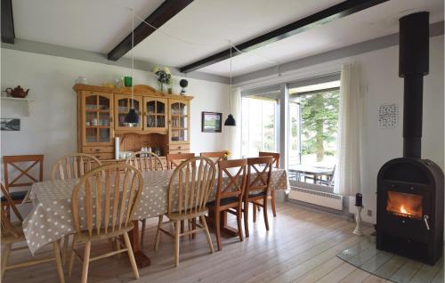 a dining room with a table and a wood stove at Holiday Home Pøt Strandby Juelsminde Ix in Sønderby