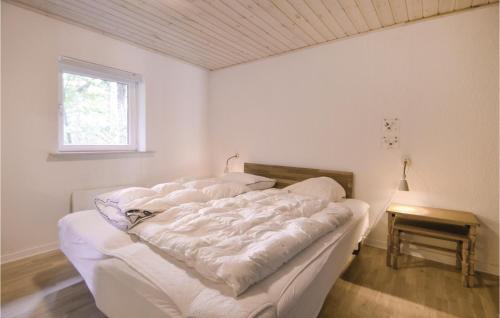 a bed with white sheets on it in a room at 2 Bedroom Cozy Home In Ebeltoft in Øksenmølle