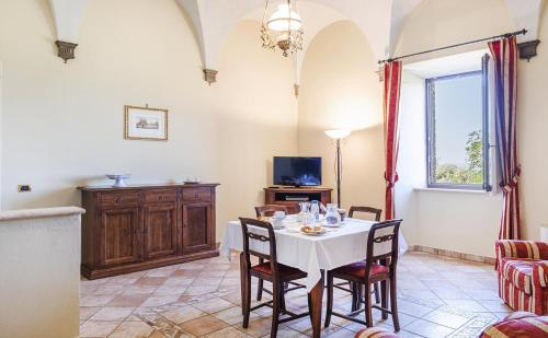 a dining room with a white table and chairs at Antica Grancia Di Quercecchio in Montalcino