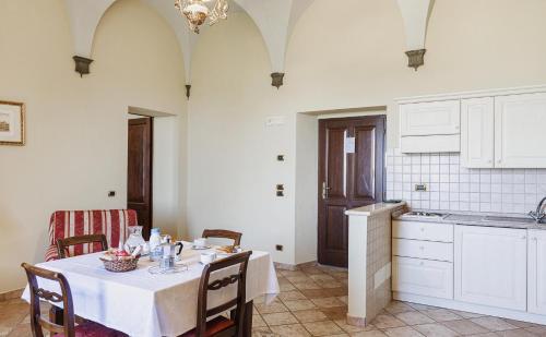 a kitchen with a table with a white table cloth at Antica Grancia Di Quercecchio in Montalcino