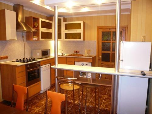 a kitchen with a counter and some chairs in it at Guest House Svoyaky in Gomel