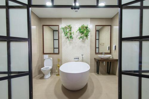 Terem Inn في كاراغاندي: حمام كبير مع حوض استحمام ومرحاض