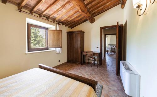 a bedroom with a bed and a dining room at Antica Grancia Di Quercecchio in Montalcino