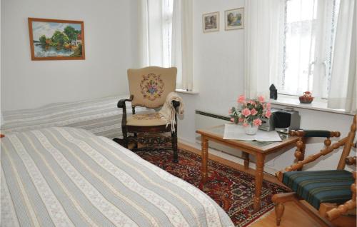 ein Schlafzimmer mit einem Bett, einem Stuhl und einem Tisch in der Unterkunft Awesome Apartment In Sydals With 2 Bedrooms in Kegnæshøj