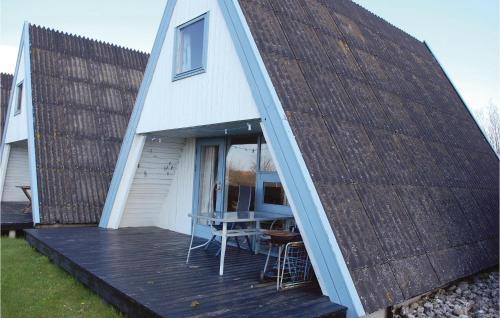 a small house with a deck with a table at 3 Bedroom Lovely Home In Knebel in Knebel