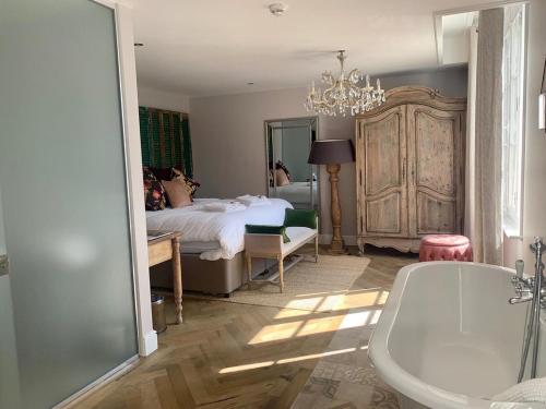 a bathroom with a bed and a tub and a bedroom at Logis Hotel De France in La Chartre-sur-le-Loir