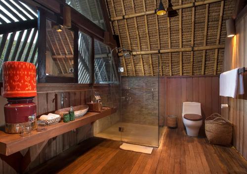 a bathroom with a toilet and a glass shower at Jeeva Beloam Beach Camp in Tanjung Ringgit