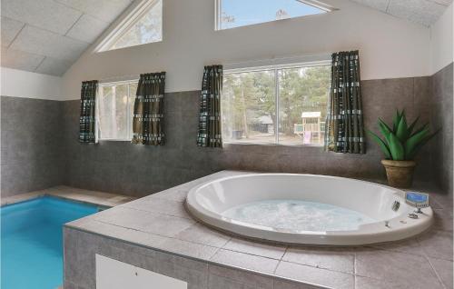 ホにあるBeautiful Home In Blvand With Sauna, Wifi And Indoor Swimming Poolの窓付きのバスルーム(大型バスタブ付)