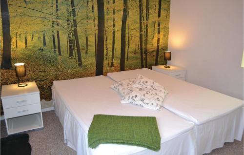um quarto com uma cama com uma pintura de uma floresta em Nice Home In Solrd Strand With Kitchen em Karlstrup Strand