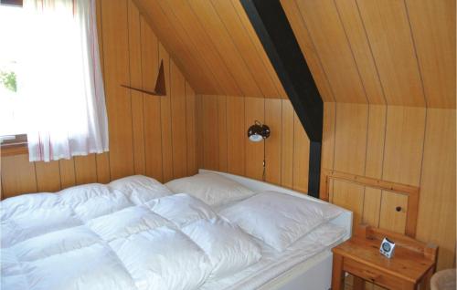 a white bed in a room with wooden walls at Holiday Home Brombærvænget Humble Vi in Humble