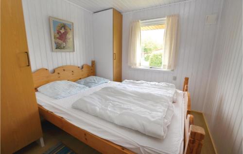 Schlafzimmer mit einem Bett mit weißer Bettwäsche und einem Fenster in der Unterkunft Stunning Home In Egernsund With Kitchen in Egernsund