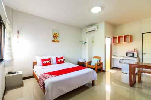 a bedroom with a large bed and a kitchen at OYO 421 Dnk Baan Suan in Lamphun