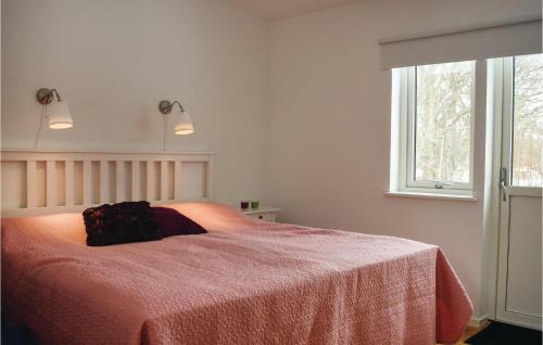 ein Schlafzimmer mit einem Bett mit einer roten Decke und einem Fenster in der Unterkunft Lovely Home In Borgholm With Wifi in Folberga