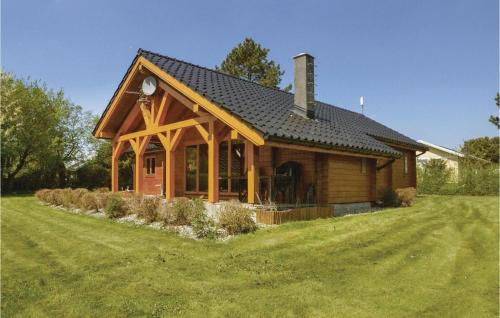 a wooden house with a large yard in front of it at Four-Bedroom Holiday Home In Hesselager in Hesselager
