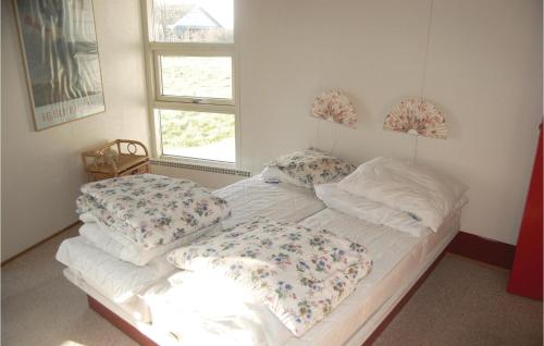 ein Bett mit zwei Kissen auf einem Zimmer in der Unterkunft Awesome Home In Sydals With Kitchen in Høruphav